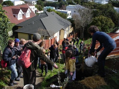 A crowd of people busy planting trees at the Brooklyn orchard planting day, 22 August 2010